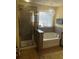The bathroom boasts a shower, a bathtub, and a window with glass blocks at 985 Forest Knoll Court, Lithia Springs, GA 30122
