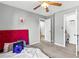 Cozy bedroom featuring a striking red headboard and ceiling fan, enhanced by ample natural light at 320 Little Creek Rd, Lawrenceville, GA 30045