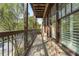 View of the outdoor balcony with brick trim, wood flooring, and wrought iron railings overlooking the street at 5920 Bond St # B206, Cumming, GA 30040