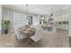 Bright dining area with a large wooden table, white chairs, and open view to a modern kitchen at 5920 Bond St # B206, Cumming, GA 30040