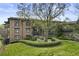 Exterior view of brick building with mature trees and manicured landscaping at 5920 Bond St # B206, Cumming, GA 30040