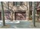 Garage doors in brick building with concrete driveway and natural landscaping at 5920 Bond St # B206, Cumming, GA 30040