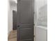 Hallway with gray door and stacked white washer and dryer at 5920 Bond St # B206, Cumming, GA 30040