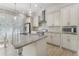 Kitchen featuring white cabinets, stainless steel appliances, and a large island with stone countertops at 5920 Bond St # B206, Cumming, GA 30040