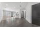 Open-concept living room with hardwood floors, dark-stained door, and view of the modern kitchen beyond at 5920 Bond St # B206, Cumming, GA 30040