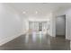 Spacious living room with hardwood floors, plantation shutters and an open view into the modern kitchen at 5920 Bond St # B206, Cumming, GA 30040