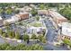 Aerial view of a vibrant town center, brick buildings, parking, outdoor dining, and green spaces at 5920 Bond St # B206, Cumming, GA 30040