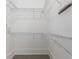 Empty walk-in closet ready for use with white metal racks along the walls and baseboards at 5920 Bond St # B206, Cumming, GA 30040