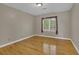 Bright bedroom with hardwood floors and a window dressed with decorative curtains at 701 Belgrave Ln, Tucker, GA 30084
