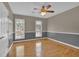 Spacious bedroom featuring hardwood floors, ceiling fan, and natural light from two windows at 701 Belgrave Ln, Tucker, GA 30084