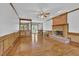 Inviting living room with hardwood floors, wood paneling, and a cozy brick fireplace at 701 Belgrave Ln, Tucker, GA 30084