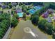 Stunning aerial view of community amenities, including a pool, tennis courts, lake, and well-manicured landscaping at 1806 Royal Troon Ct, Duluth, GA 30097