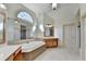 Luxurious bathroom featuring a jacuzzi tub, tile flooring, and a large window offering plenty of natural light at 1806 Royal Troon Ct, Duluth, GA 30097