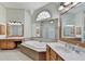 Bright bathroom featuring double sinks, a large jacuzzi tub, tile flooring and plenty of cabinet space for storage at 1806 Royal Troon Ct, Duluth, GA 30097