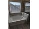 Bathroom featuring a white soaking tub and a large window to allow natural light at 586 Rodeo Dr, Auburn, GA 30102