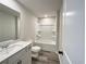 Clean bathroom features shower and tub combo, white countertops, white cabinets, and modern fixtures at 586 Rodeo Dr, Auburn, GA 30102