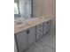 Bathroom featuring double vanity with gray cabinets, modern hardware, and a large mirror at 586 Rodeo Dr, Auburn, GA 30102