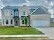 Charming two-story home featuring a brick facade, well-manicured lawn, and a two-car garage at 586 Rodeo Dr, Auburn, GA 30102