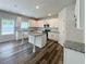 Bright kitchen features granite countertops, a center island, stainless appliances, and stylish wood flooring at 586 Rodeo Dr, Auburn, GA 30102