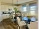 Eat-in kitchen boasts white cabinetry, stainless appliances, granite counters and dining area at 586 Rodeo Dr, Auburn, GA 30102