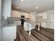 Bright kitchen features granite countertops, a center island, stainless appliances, and stylish wood flooring at 586 Rodeo Dr, Auburn, GA 30102