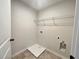 This laundry room features tile flooring, a shelf, and washer and dryer hookups at 586 Rodeo Dr, Auburn, GA 30102