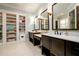 Elegant bathroom with dual vanities, decorative mirrors, and built in shelving for storage at 1762 Patrick Rd, Dacula, GA 30019
