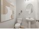 Elegant powder room with modern fixtures, decorative mirror, and neutral color scheme at 8511 Polston Place- Lot 138, Douglasville, GA 30134