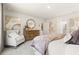 Bright bedroom featuring neutral decor, a dresser with a round mirror, and a sitting chair with decorative pillows at 8511 Polston Place- Lot 138, Douglasville, GA 30134
