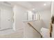 Upstairs hallway with neutral walls, a staircase, and doorways leading to rooms with decor at 8511 Polston Place- Lot 138, Douglasville, GA 30134