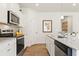 Stylish kitchen features stainless appliances, white cabinets, granite countertops, and modern fixtures at 8511 Polston Place- Lot 138, Douglasville, GA 30134