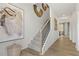 Bright foyer with staircase featuring gray carpet, black railings and light wood trim, leading to the upper level at 8511 Polston Place- Lot 138, Douglasville, GA 30134