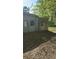 Backyard view featuring an old storage building with concrete attached, surrounded by leaves at 1099 Warren Dr, Riverdale, GA 30296