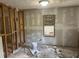 Bedroom being remodeled with walls partially covered with drywall and a window at 1099 Warren Dr, Riverdale, GA 30296