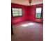 Bedroom with vibrant red walls, natural light streaming in from two windows, and hardwood floors at 1099 Warren Dr, Riverdale, GA 30296