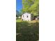 Quaint one-story home featuring a covered porch and surrounded by mature trees on a spacious lot at 1099 Warren Dr, Riverdale, GA 30296