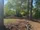 Exterior view of the home from a distance, surrounded by trees in a greenery filled lot at 1099 Warren Dr, Riverdale, GA 30296