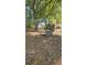 Exterior view of the house from a distance with trees in a greenery filled lot and concrete structures at 1099 Warren Dr, Riverdale, GA 30296