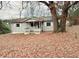 Charming bungalow-style home with a covered front porch surrounded by colorful autumn foliage at 1099 Warren Dr, Riverdale, GA 30296