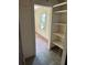 Hallway with exposed shelving and a view of a bedroom with a window, showing the house's layout at 1099 Warren Dr, Riverdale, GA 30296