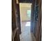 Hallway with exposed studs, looking into a brightly lit room with a window and damaged floors at 1099 Warren Dr, Riverdale, GA 30296
