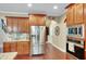 Well-equipped kitchen with stainless steel refrigerator, granite countertops, and custom wood cabinetry at 1705 Butler Bridge Rd, Covington, GA 30016