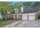 Charming brick home features a two-car garage, dormer windows, and a welcoming front entrance at 495 Buttercup Trl, Lawrenceville, GA 30046