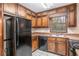 Functional kitchen with wooden cabinets, laminate countertops, and black appliances at 495 Buttercup Trl, Lawrenceville, GA 30046