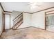 A blank living room with carpet, a staircase, and neutral walls at 495 Buttercup Trl, Lawrenceville, GA 30046