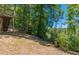 An elevated deck with stairs leading down to a sloping grassy backyard with mature trees and greenery at 1850 Brooks Pointe Ct, Lawrenceville, GA 30045