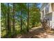 Backyard view featuring trees, greenery, and a deck with stairs, offering a serene outdoor retreat at 1850 Brooks Pointe Ct, Lawrenceville, GA 30045