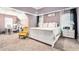 Light-filled bedroom boasts a white bed frame, yellow chair, and neutral carpet for a cozy and inviting feel at 1850 Brooks Pointe Ct, Lawrenceville, GA 30045