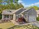Charming home with a well-manicured lawn, blooming flowerbeds, and a cozy front porch sitting area at 201 Aster Ct, Canton, GA 30114