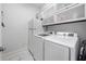 Bright laundry room features white washer and dryer, and upper cabinet storage at 201 Aster Ct, Canton, GA 30114